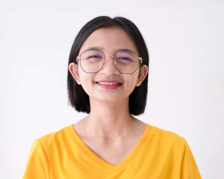 Asian girl wear glasses and yellow T-shirt on white background.の写真素材