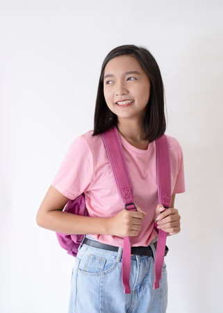 Young asian girl wear pink shirt and jean with pink backpacl on white background.