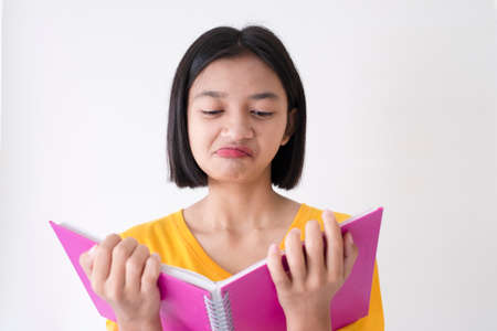 Young girl hold pink book wear yellow shirt and short hair,on white background.