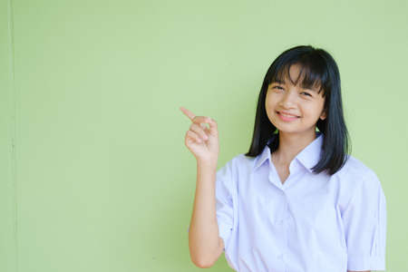 portrait student young girl in uniform school on green background, Asian girl, Teenager.の写真素材