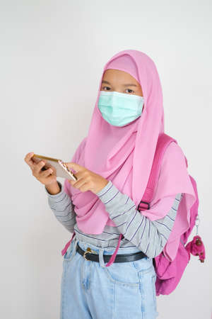 Muslim young girl use a mobile phone on white background.の写真素材
