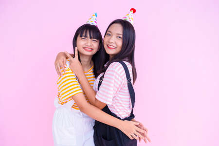 Happy girls wear party hat palying on pink background.の写真素材
