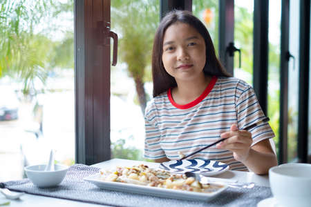A girl is having a delicious meal at a restaurant.の写真素材
