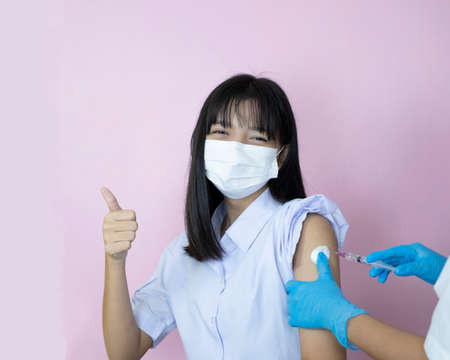 Asian student vaccination on pink background.の写真素材