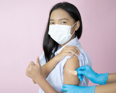Asian student vaccination on pink background.の写真素材