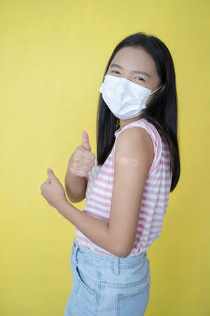 Beautiful young girl vaccination ,wear mask.の写真素材