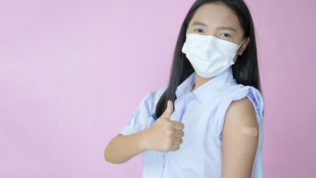Asian student vaccination on pink background.の写真素材
