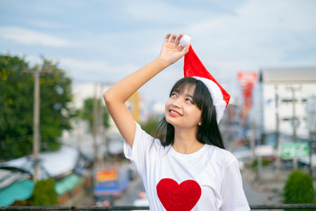 Happy young girls wear Christmas hat on city view background.の写真素材