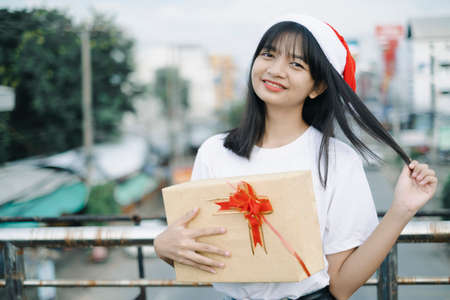 Happy young girls wear Christmas hat on city view background.の写真素材