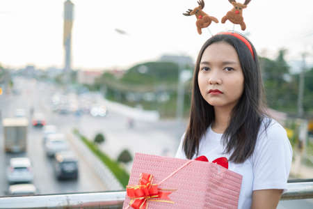 Happy young girls wear Christmas hat on city view background.の写真素材