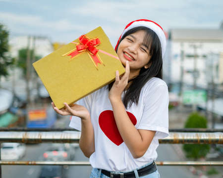 Happy young girls wear Christmas hat on city view background.の写真素材