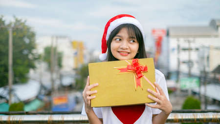 Happy young girls wear Christmas hat on city view background.の写真素材