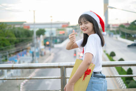 Happy young girls wear Christmas hat on city view background.の写真素材
