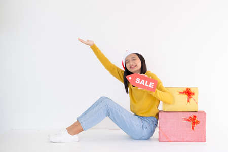Happy young girl hold present box , Asian girl wear yellow sweater on white background.の写真素材