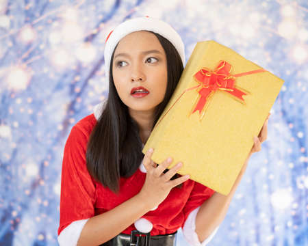 Happy Santa Claus girl hold present box with snow background.の写真素材