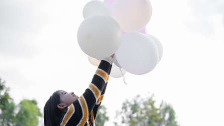 Happy young girl hold balloon at the maedow on winter.の写真素材