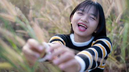 Happy young girl at the meadow with beautiful light before sunset time.