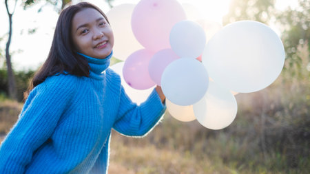 Happy young girl hold balloon at the maedow on winter.の写真素材
