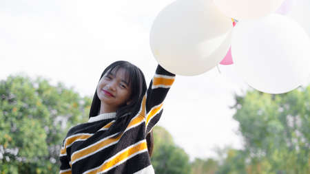 Happy young girl hold balloon at the maedow on winter.の写真素材