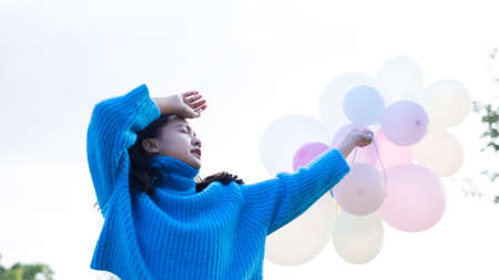 Happy young girl hold balloon at the maedow on winter.の写真素材