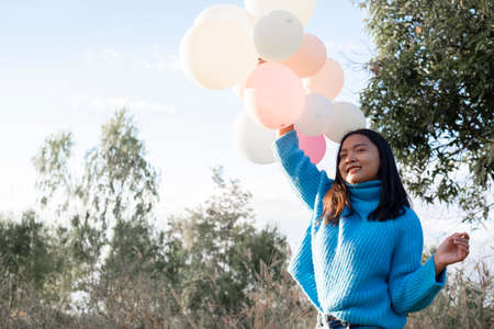 Happy young girl hold balloon at the maedow on winter.の写真素材