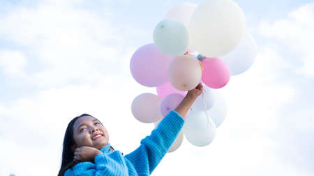 Happy young girl hold balloon at the maedow on winter.の写真素材