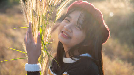 Happy young girl at the meadow with beautiful light before sunset time.の写真素材