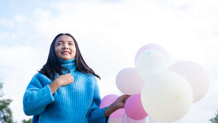 Happy young girl hold balloon at the maedow on winter.の写真素材