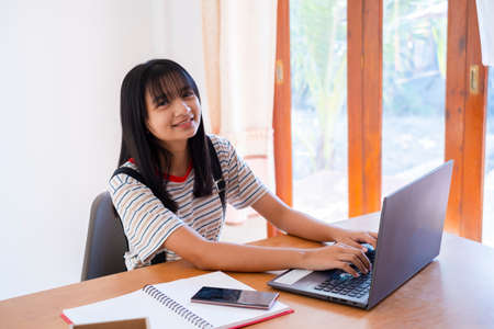 Happy young girl study at home with laptop ,home school.