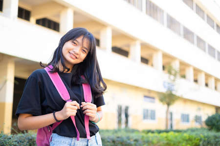 Student young girl hold pink book and backpack at school,back to school.の写真素材