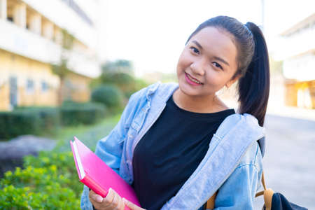 Happy student girl hold book and backpack at school, Asian girl.の写真素材