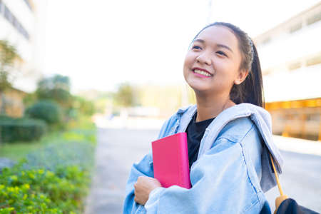 Happy student girl hold book and backpack at school, Asian girl.の写真素材
