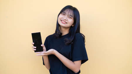 Portrait young girl use mobile on orang baclground.の写真素材