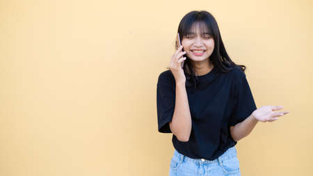 Portrait young girl use mobile on orang baclground.の写真素材