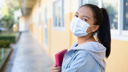 Student young girl wear mask walking at school.の写真素材