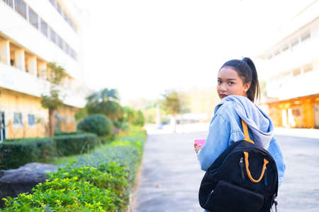 Happy student girl hold book and backpack at school, Asian girl.の写真素材