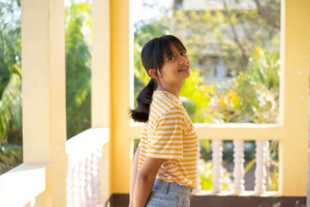 Happy student asin girl standing with green and yellow background.の写真素材