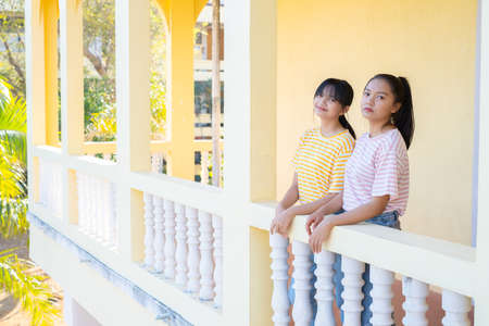 Two happy ypung girl standing together at school.