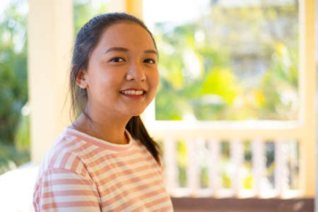 Happy student asin girl standing with green and yellow background.