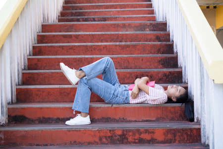 Student young girl lay down on stairs at shool.の写真素材