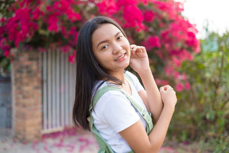 Portrait Young Asian girl outdoor, beautiful flower background.の写真素材