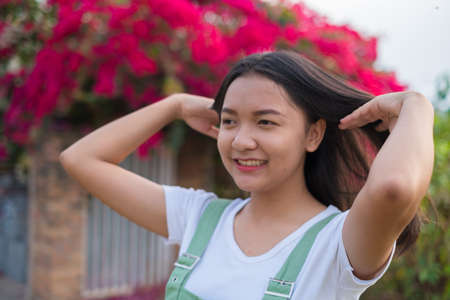 Portrait Young Asian girl outdoor, beautiful flower background.の写真素材