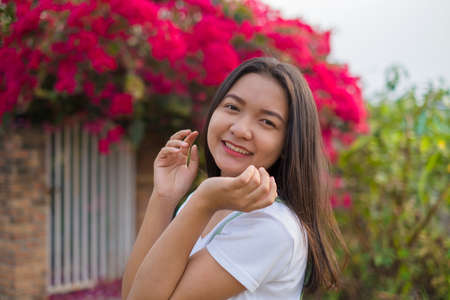 Portrait Young Asian girl outdoor, beautiful flower background.の写真素材