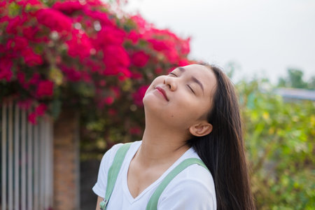 Portrait Young Asian girl outdoor, beautiful flower background.の写真素材