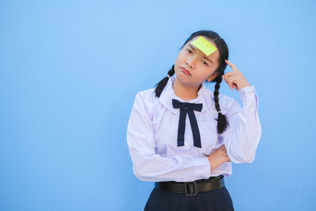 Student with book and small note paper on blue background.の写真素材