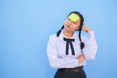 Student with book and small note paper on blue background.の写真素材