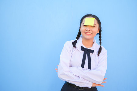 Student with book and small note paper on blue background.