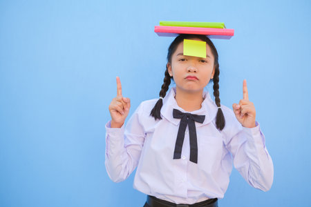 Student with book and small note paper on blue background.の写真素材