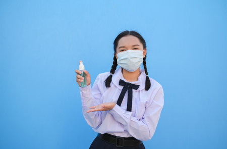 School girl wear mask on blue background,Back to school.の写真素材