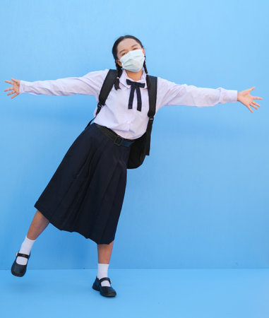 School girl wear mask on blue background,Back to school.の写真素材